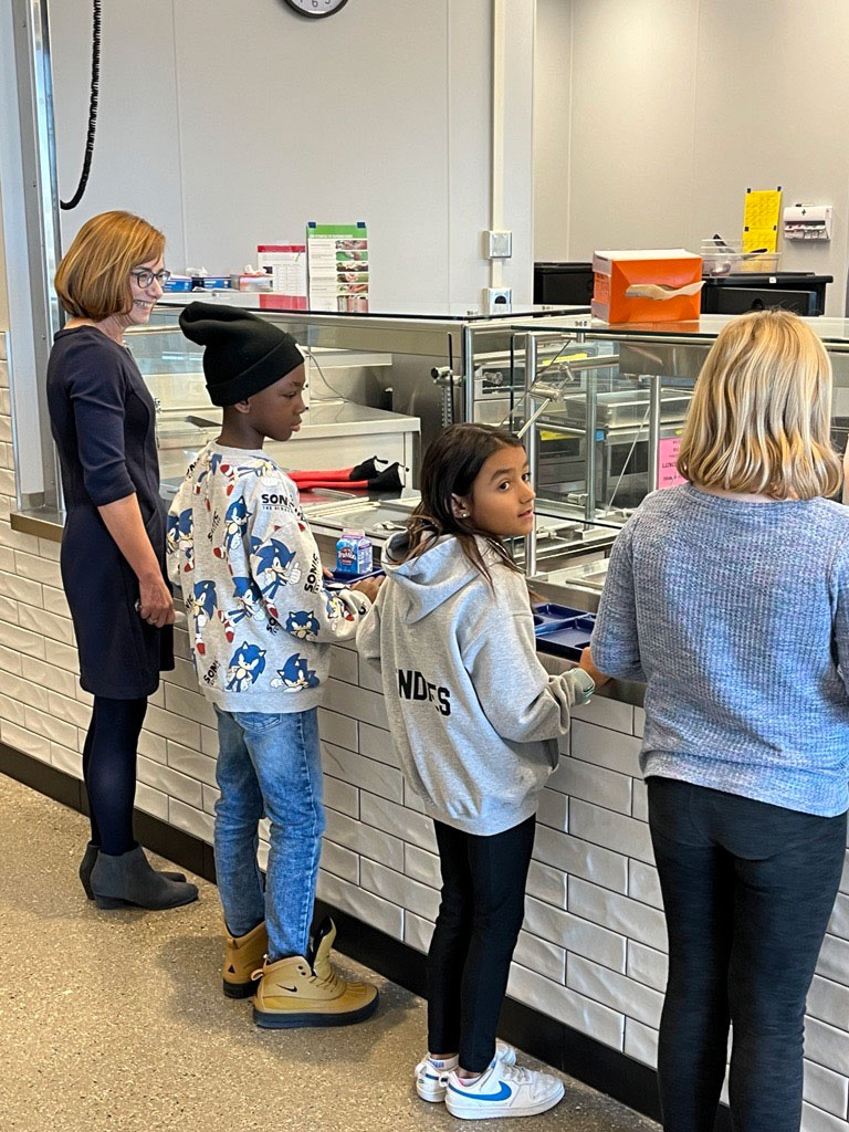 FNS Administrator Cindy Long waits for a nutritious and delicious school lunch with students from Granite Ridge School in Cottage Grove, Wisconsin