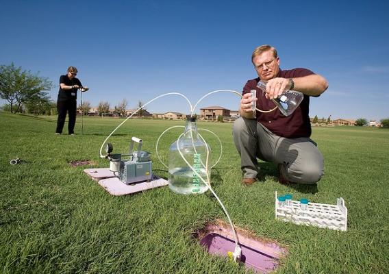Agricultural Research Service soil scientist Clinton Williams draws water samples from a large lysimeter