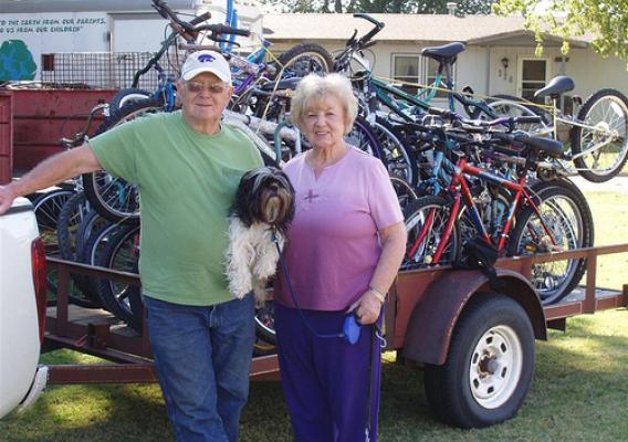 Earth Team Volunteer Robert Mosier and his friend Marcella Thomas stand in front of a trailer full of refurbished, soon-to-be-donated bicycles with Jack the dog.  NRCS recognizes Robert as its top volunteer for 2011.    