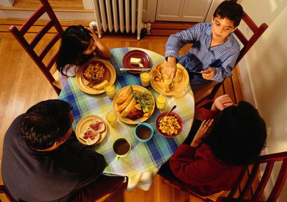 Family of four has dinner together. New USDA report examines the anti-poverty effects of the Supplemental Nutrition Assistance Program (SNAP). Photo: Thinkstock