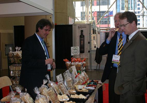 Antonio Galati, La Panzanella’s director of business development (left), exhibits some of his company’s specialty crackers, otherwise known as croccantini, to visitors attending the SIAL food trade show in Canada earlier this year. This Seattle-based company has expanded their international exports with help from USDA’s Foreign Agricultural Service market export programs and by attending USDA-endorsed international food and trade shows. (Photo courtesy of USDA’s Foreign Agricultural Service) 