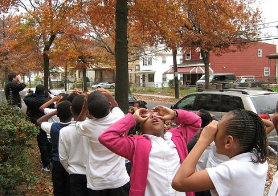 Students from the Paul Public Charter School in Washington, D.C., take to the streets pretending to use binoculars in search of their urban forest with a member of the Missoula (Montana) Chlidren's Theatre. The Missoula Children's Theatre works with the U.S. Forest Service to develop interactive, engaging performing arts school assemblies and workshops.