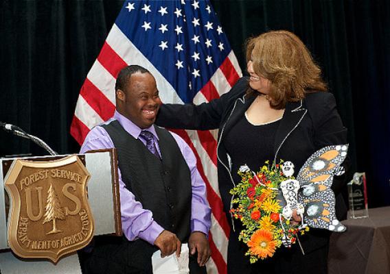 Receiving the award for “Communities in Conservation” are Luisa Lopez, Counselor at El Valor and Vincent Jordan, participant in El Valor's Adults with Different Abilities Program. They are holding one of the products of this program—a monarch butterfly made for Día de los Muertos, or Day of the Dead.