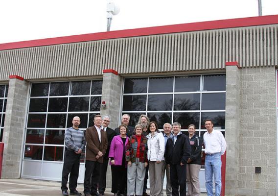 A new storm warning siren has been installed above the fire hall in Lake Benton, Minn. Officials from the USDA and Lincoln County gathered in Lake Benton recently to highlight how USDA funding helped four communities in Lincoln County purchase and install new storm sirens.  Minnesota Rural Development State Director Colleen Landkamer is pictured fourth from the left. 