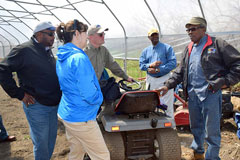 Avon Standard, an urban farmer from Cleveland, Ohio (right, foreground) speaks to Terry Cosby, former state conservationist in Ohio (left, background) and others in Standard’s hoop house during an urban tour on his farm in 2016