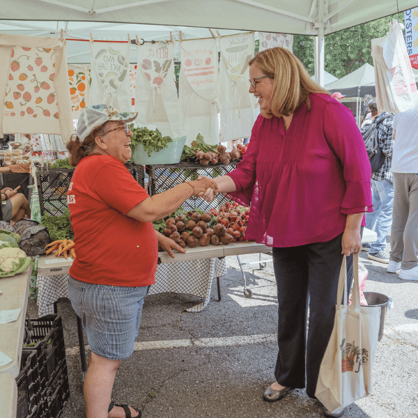 Agriculture Under Secretary for Marketing and Regulatory Programs Jenny Lester Moffitt greets a vendor at the USDA Farmer's Market.