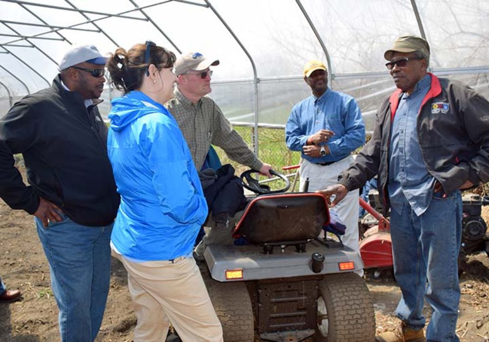 Avon Standard, an urban farmer from Cleveland, Ohio (right, foreground) speaks to Terry Cosby, former state conservationist in Ohio (left, background) and others in Standard’s hoop house during an urban tour on his farm in 2016. Standard is the first urban farmer in Cleveland to apply for a high tunnel under Cleveland’s High Tunnel Initiative