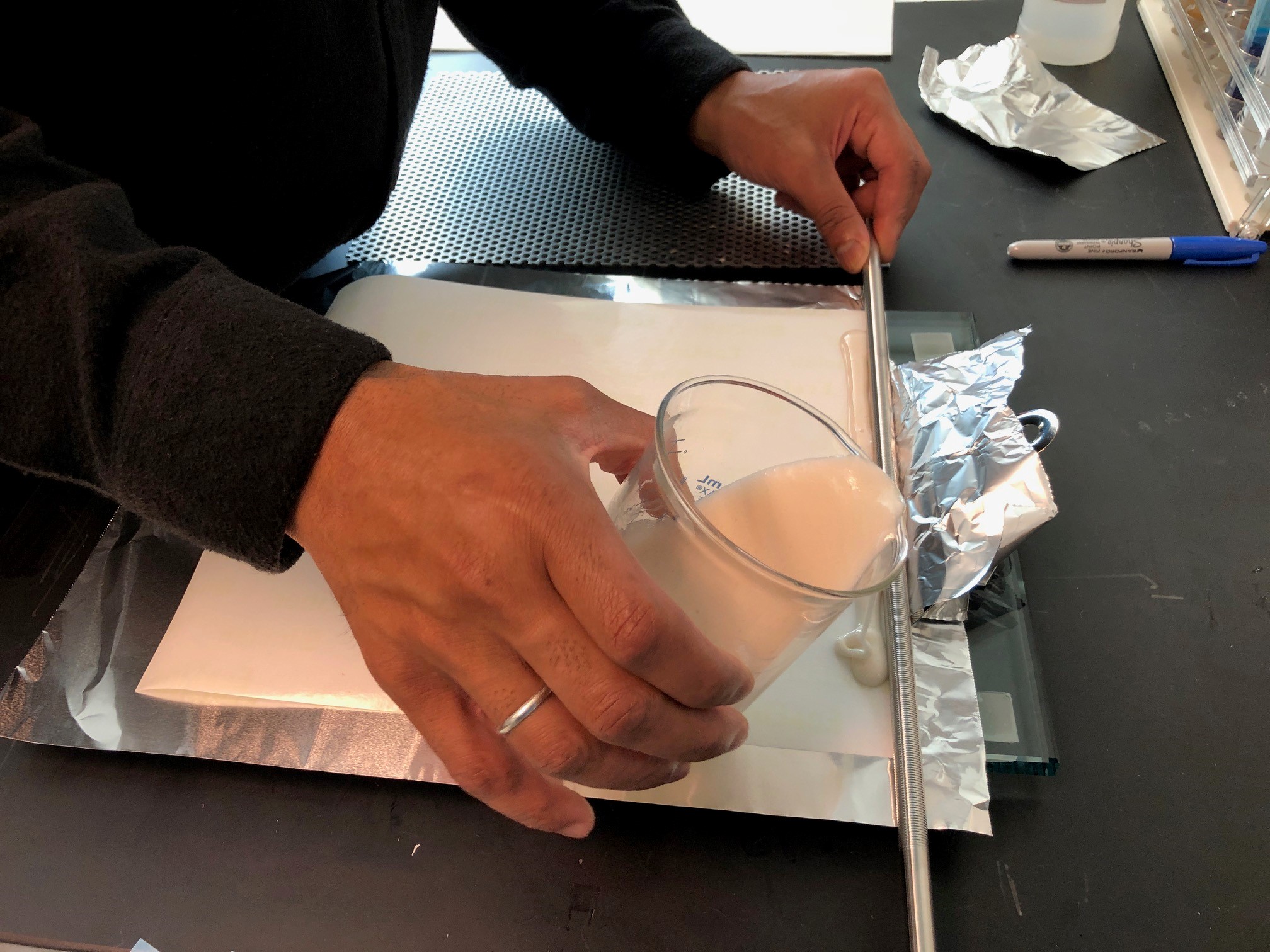 A scientist pours an experimental adhesive compound during the research process
