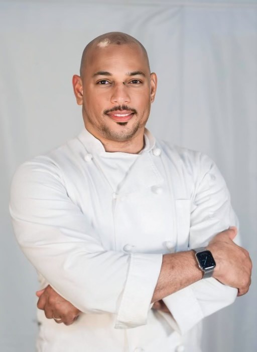 Foto de perfil de un hombre con una bata de chef.