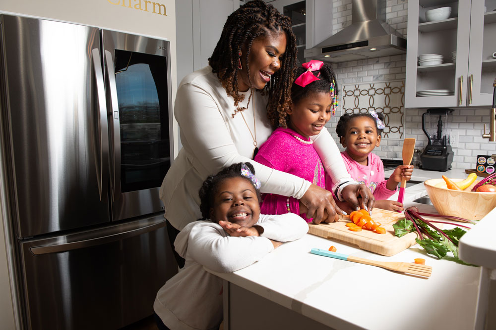 La Dra. Cotwright y sus tres hijas preparan una comida saludable en la cocina.