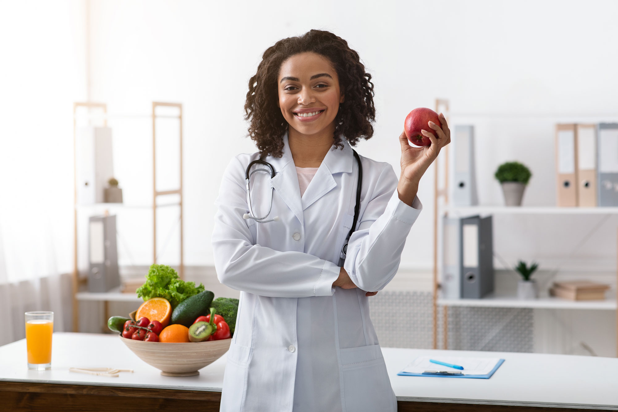 A dietitian smiling with an apple