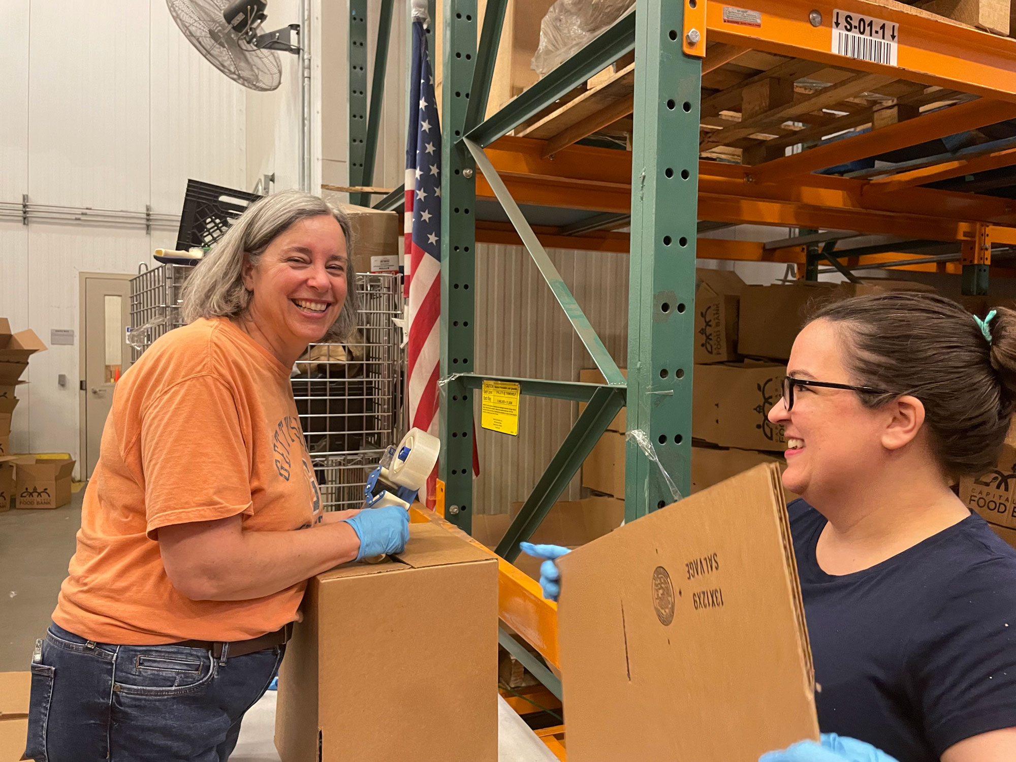 USDA Deputy Undersecretary for Food, Nutrition and Consumer Services Stacy Dean and FNS employee Jilian Kozjar pack boxes of food at the Capital Region Food Bank in Washington, D.C. DC.