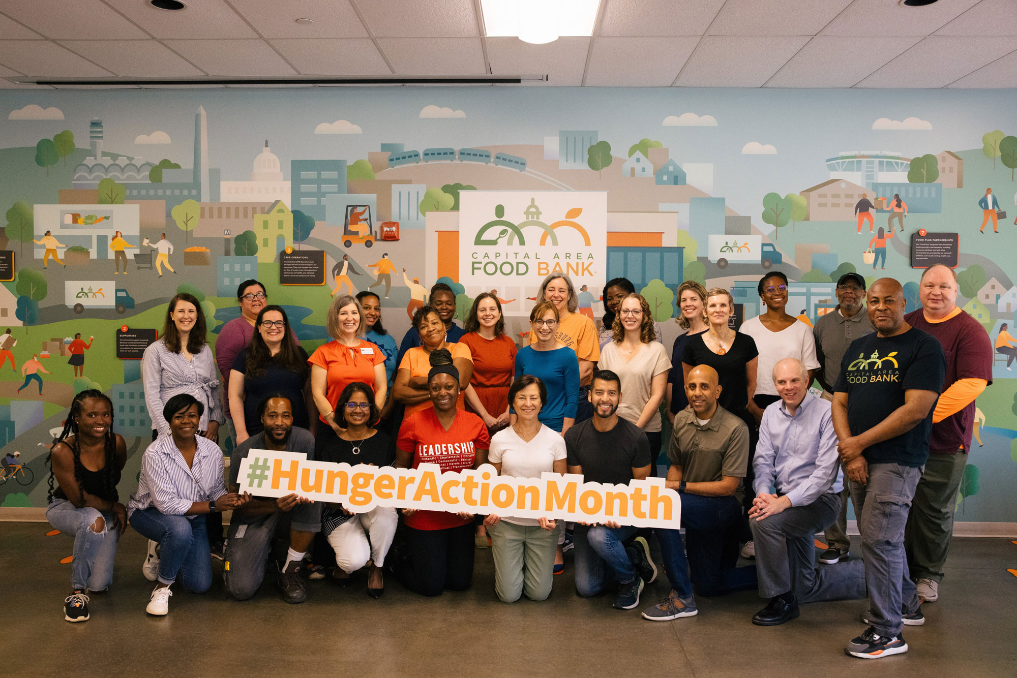 Leaders and employees of the USDA Food and Nutrition Service and the Capital Area Food Bank pose for a photo after packing boxes of food for the needy.