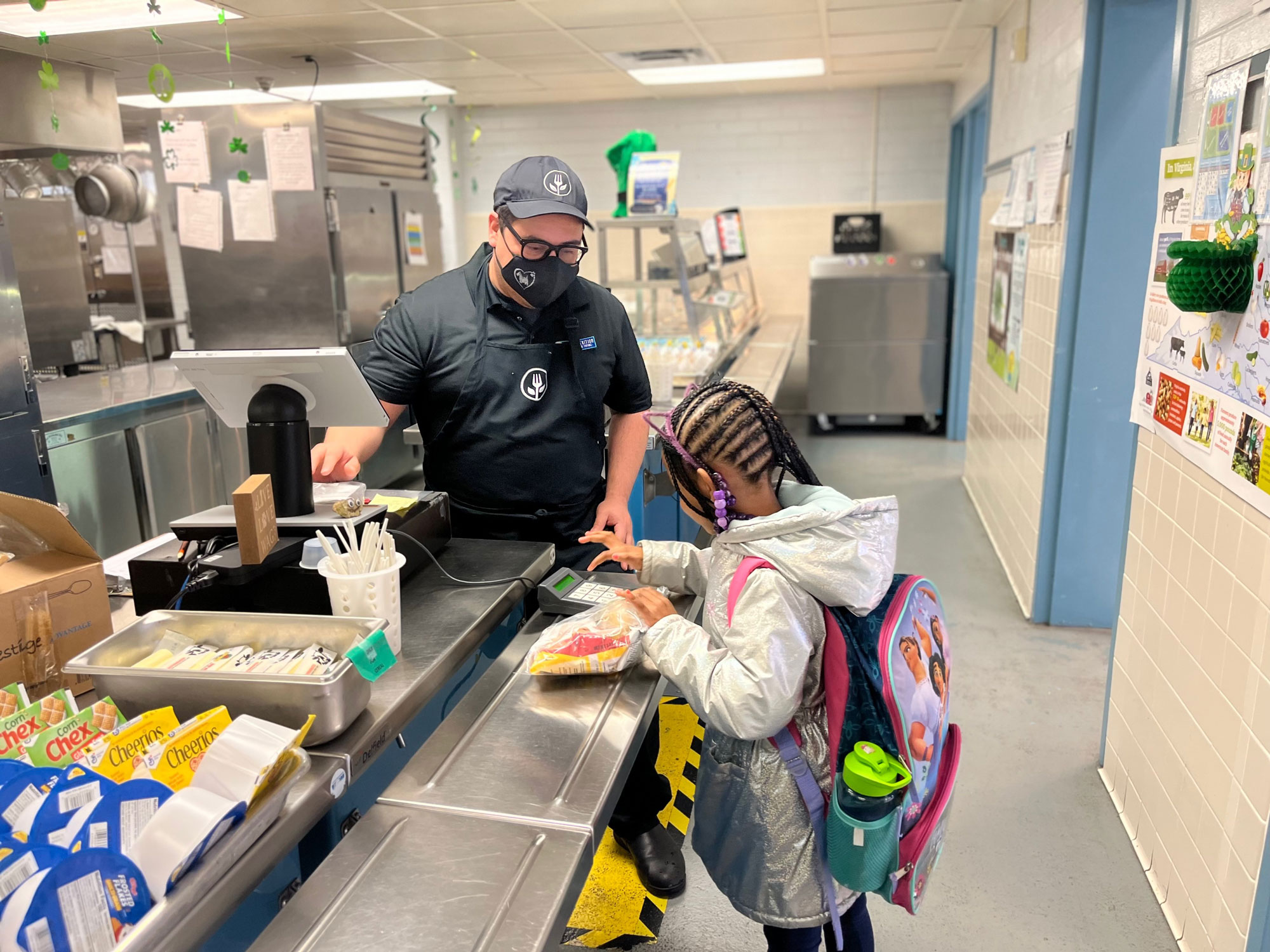 Student receives breakfast from school meal professional in the school kitchen