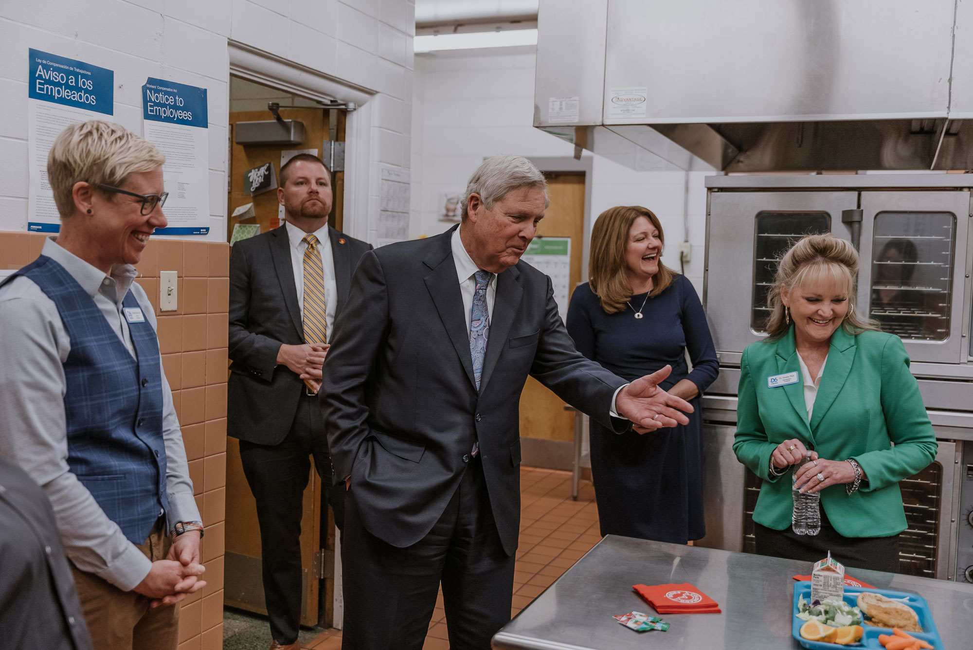 Danielle Bock, Greeley Evans Director of Nutrition Services; Melissa Rothstein, USDA Associate Administrator for Child Nutrition; Dr. Deirdre Pilch, Greeley Evans Superintendent and Secretary Tom Vilsack observe a school meal tray in the Maplewood Elementary School kitchen