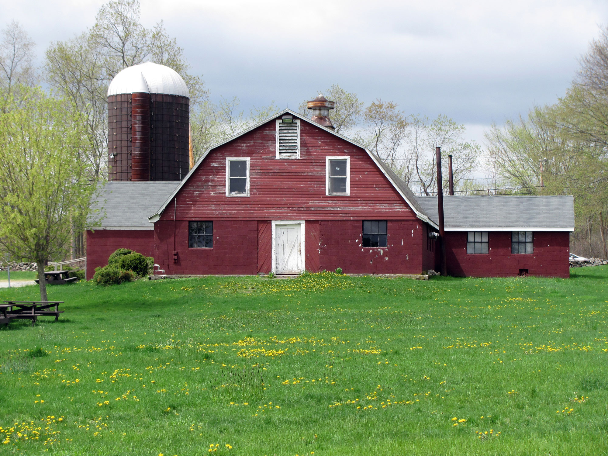 A rustic red barn on a New England farm in spring
