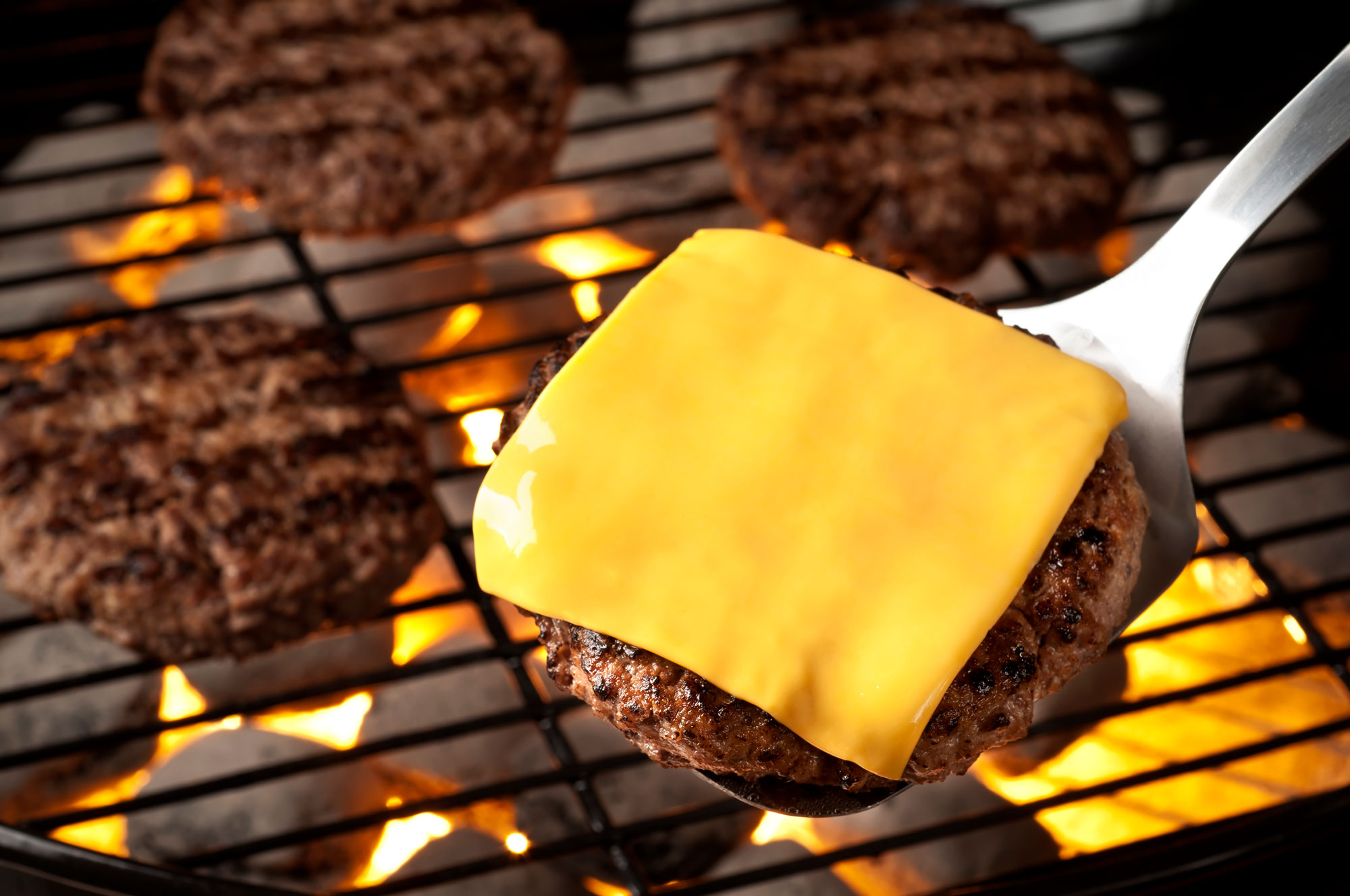 A burger with cheese on the grill