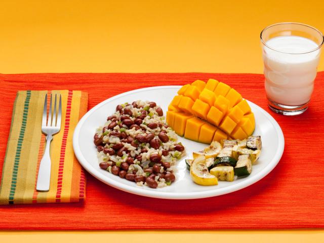 A plate of food and a glass of milk on a mat