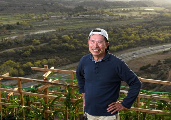 California farmer Leonardo Aguila smiles standing in front of his dragon fruit crop
