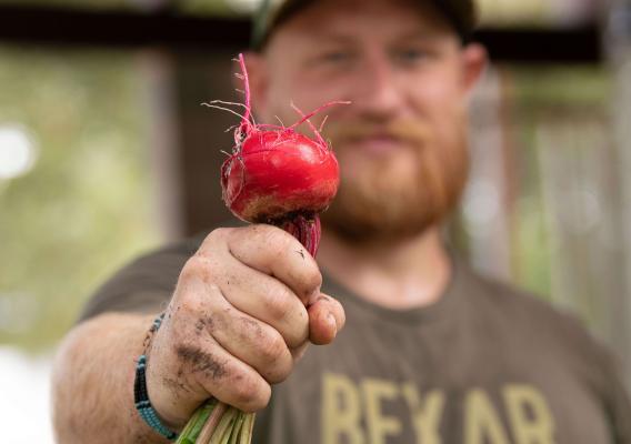 Farmer Cody Scott presents a freshly-harvested red beet grown on Green Bexar Farm, in Saint Hedwig, Texas, near San Antonio