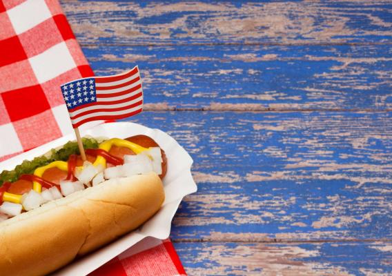 A hotdog with a US flag on top of the hotdog