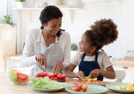 Image of mother and daughter chopping vegetables to prepare a healthy meal