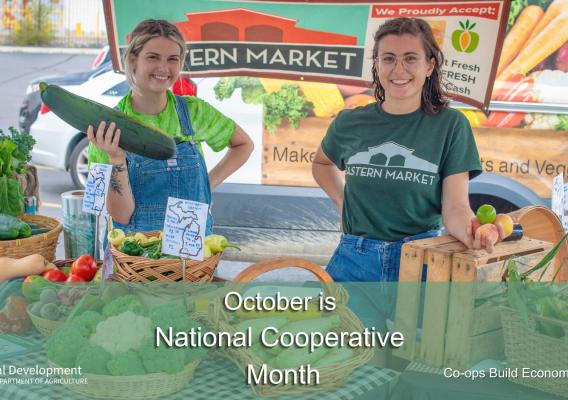A woman smiling holding a cucumber and another woman smiling at the market with October is National Cooperative Month text overlay
