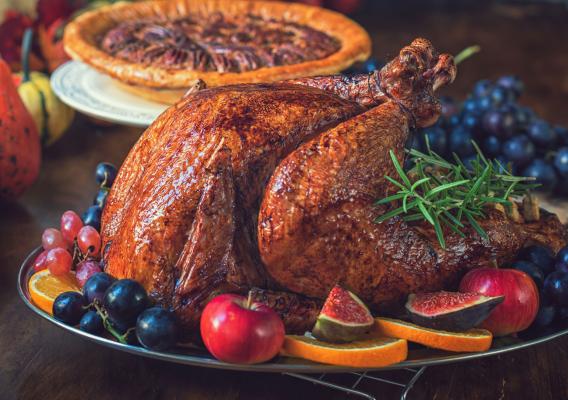 A turkey and a pie with different fruits on plates