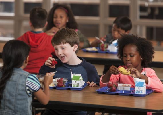 Elementary school students eating school breakfast in the cafeteria