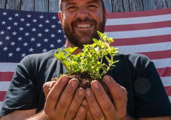 U.S. Marine Corps veteran Calvin Riggleman holds an oregano seedling and soil on Bigg Riggs farm