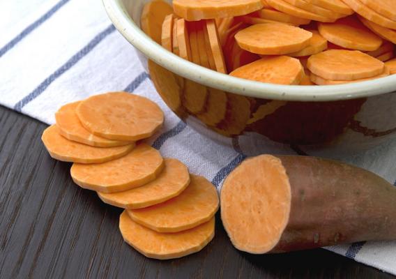 Sweet potato on wooden table and in the bowl