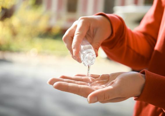Woman using hand gel outdoors