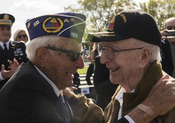WWII veterans embracing each other during the WWII Bronze Star Award Ceremony at the National WWII Memorial