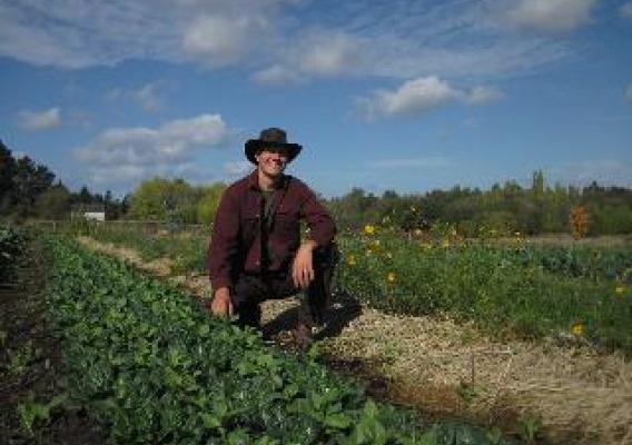 Paul Kaiser on Singing Frogs Farm, poised between crops and pollinator habitat.