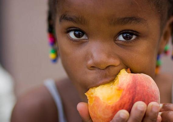 A girl eating a peach