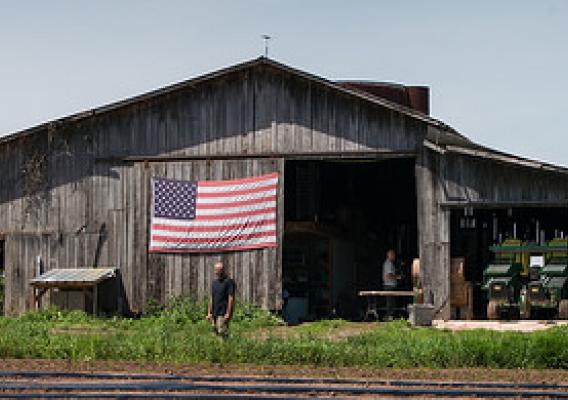 U.S. Marine Corps veteran Calvin Riggleman standing in front of a U.S. flag displayed on a barn on Bigg Riggs farm in Hampshire County, WV