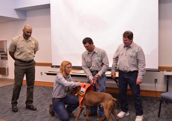 APHIS Wildlife Services program specialist Mario Eusi and his dog Cain at their graduation ceremony