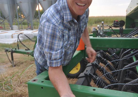 Jonathan Cobb holding grain near his tractor