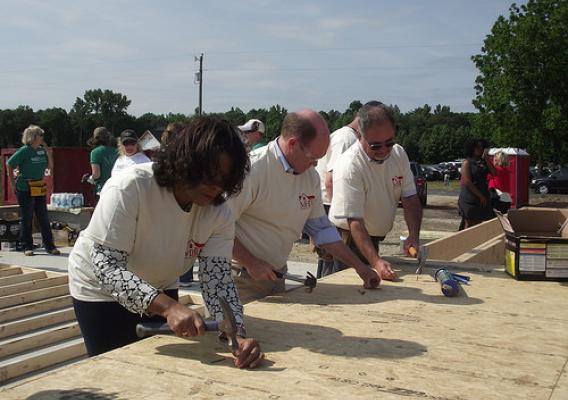 United States Senator Chris Coons (center) joining USDA Deputy Under Secretary for Rural Development (RD) Vernita Dore, RD’s Delaware State Director Bill McGowan and dozens of RD and community volunteers to help build a home