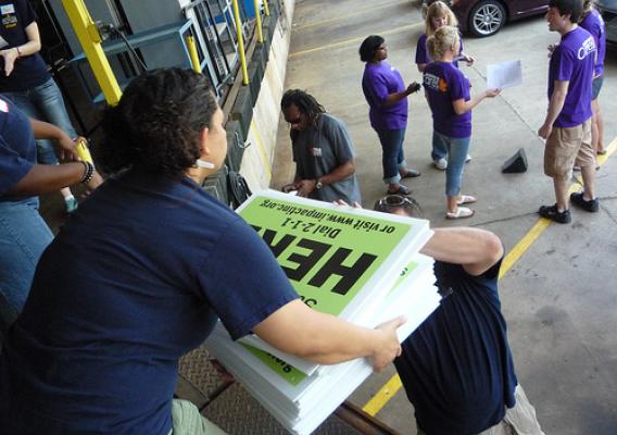 Volunteers from Kohl’s load signs that advertise USDA summer meals for kids into their cars at the loading dock of Wisconsin’s largest food bank.
