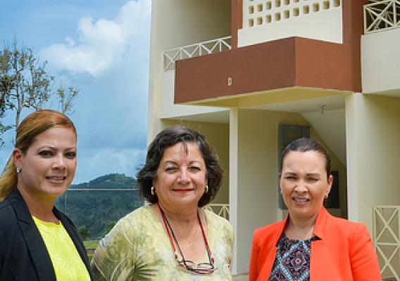 Dianilda Rodriguez of GR Management Corp., Arlene Zambrana from USDA Rural Development, and Maria Rodriquez-Collazo of PathStone standing in front of the completed Alturas de Castañer housing complex