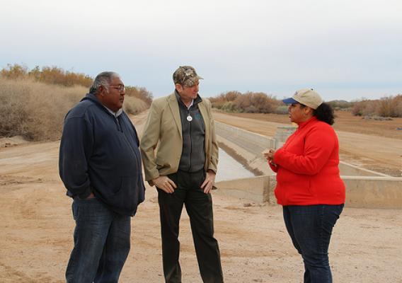 NRCS State Conservationist Keisha Tatem, NRCS Assistant Chief Kirk Hanlin (center) and Eric Juan with the Gila River Tribal Community discuss the efficiency gains of the concrete-lined irrigation ditch in the community. Before this ditch was lined, much of the water was lost. NRCS photo.