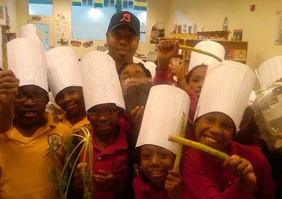 Students at Chicago’s Kwame Nkrumah Academy pose with Real Men Cook’s Marvin Brown during a recent Chefs Move to Schools event.