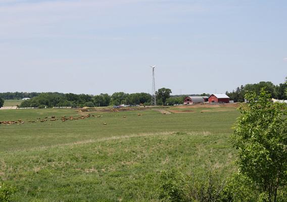 View of the Priske Farm, with USDA funded wind generator, from the restored prairie field. 