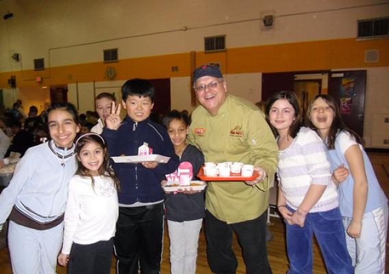 Chef Paul Penney poses with Eriksson Elementary School students in Canton, MI. He is holding a tray of tasting cups so students can sample his new recipes. Photo credit: Patty Russo.
