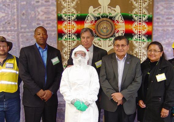 Dr. Scott Bender (Navajo Tribal Veterinarian), Rodney White (APHIS VS National Veterinary Stockpile Director), Edward Avalos (USDA Marketing and Regulatory Programs Under Secretary ), Ben Shelly (Navajo Nation President), Vangie Curley-Thomas (Navajo Division of Natural Resources Assistant Director), and Glenda Davis (Navajo Nation Veterinary and Livestock Program Director). In front of the Under Secretary is an agriculture responder donning personal protective equipment