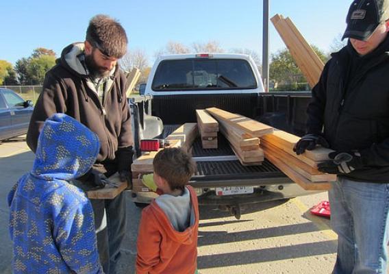 Agricultural research science technician Fred Engstrom (left), a parent volunteer and two Central Elementary students measuring out lumber