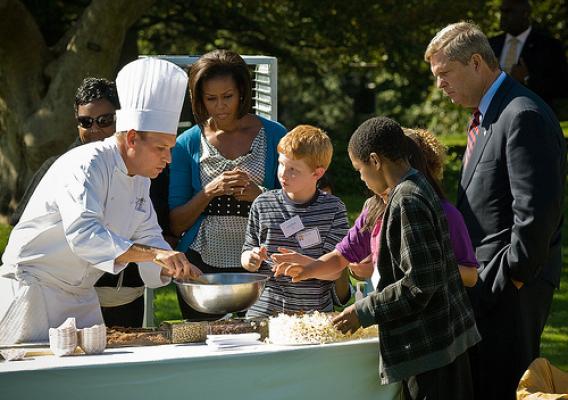 Young chefs prepare food with First Lady Michelle Obama and Secretary Vilsack.