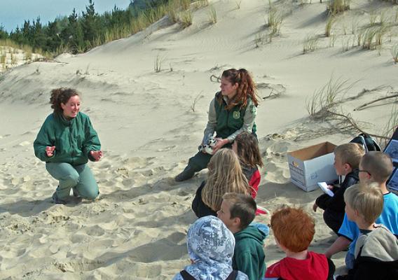 Field rangers, Eliza Spear (left) and Meghan Avila (right) teach Siuslaw Elementary second graders about Snowy Plovers shorebirds. (U.S. Forest Service photo)