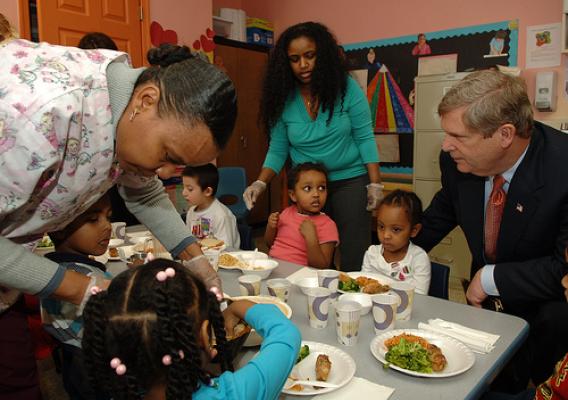 Agriculture Secretary Tom Vilsack helps students with their lunch at the Edward C. Mazique Parent Child Care Center in Washington, D.C. on Thursday, Feb. 4, 2010.  Secretary Vilsack is assisted by (L to R) Melkam Mekuria, Center Director and Freida Phiffer, Teacher Assistant. Agriculture Secretary Tom Vilsack and Health and Human Services (HHS) Secretary Kathleen Sebelius were at the facility to celebrate the one year anniversary of the Children’s Health Insurance Program Reauthorization Act (CHIPRA). Photo